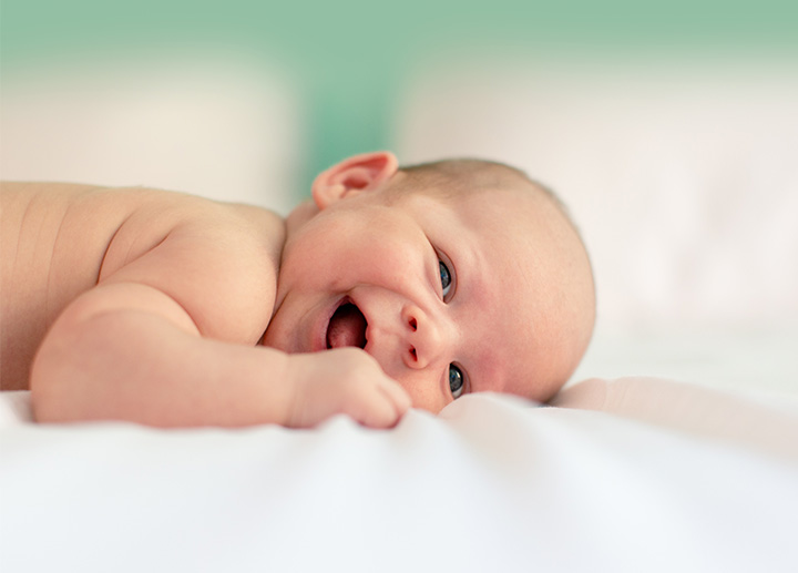 Baby smiling on top of a changing table