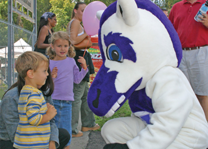 Western's Mustang mascot talking to a child