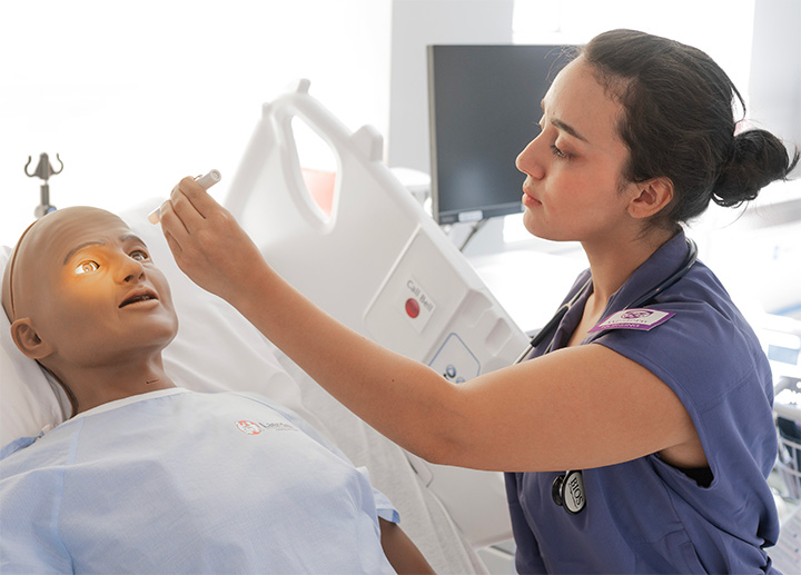 A nursing student learning with a manakin.