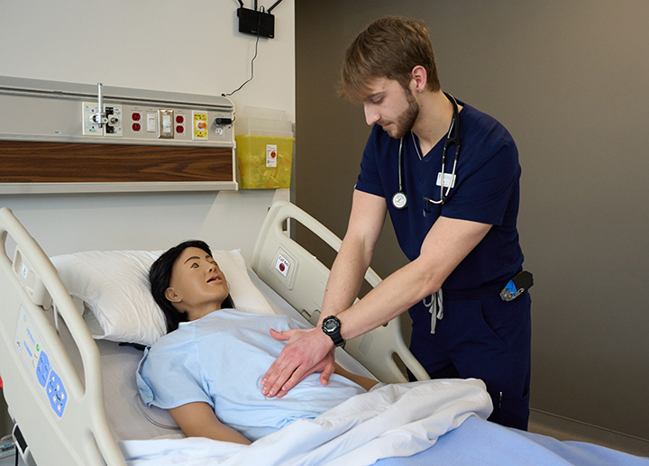 A nursing student learning with a manakin.