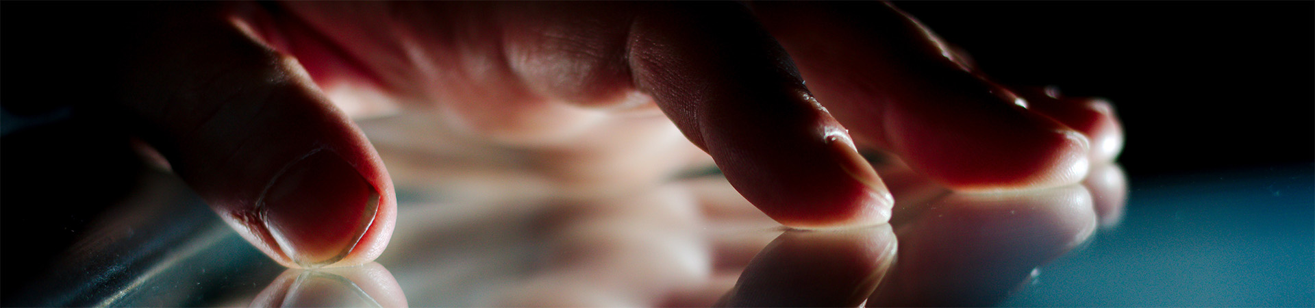 A hand placed against a reflective surface.