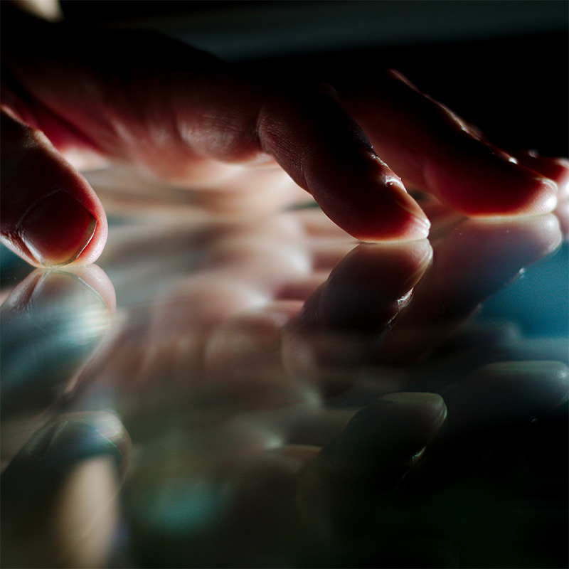 A hand placed against a reflective surface.