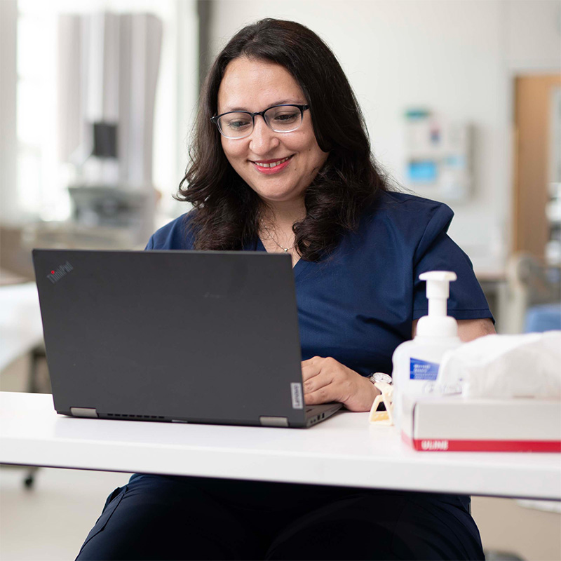 A nursing student working on their laptop.