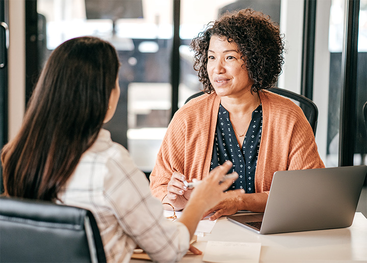 A medical professional speaking with someone in their office.