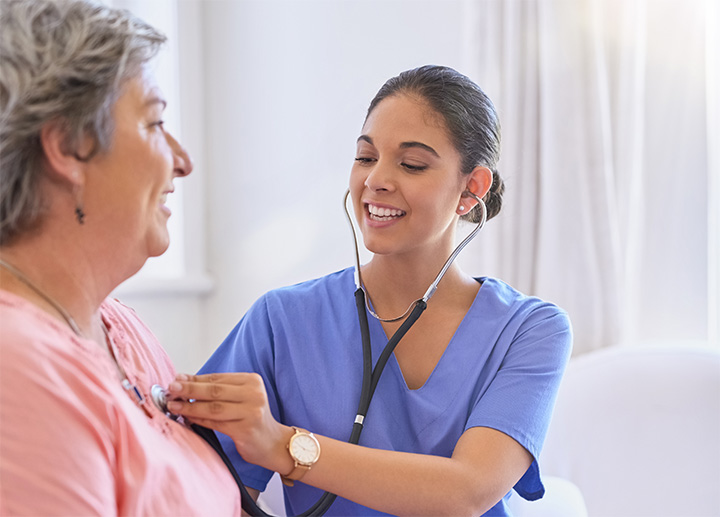 A healthcare professional checking a patient's heart with a stethoscope. 