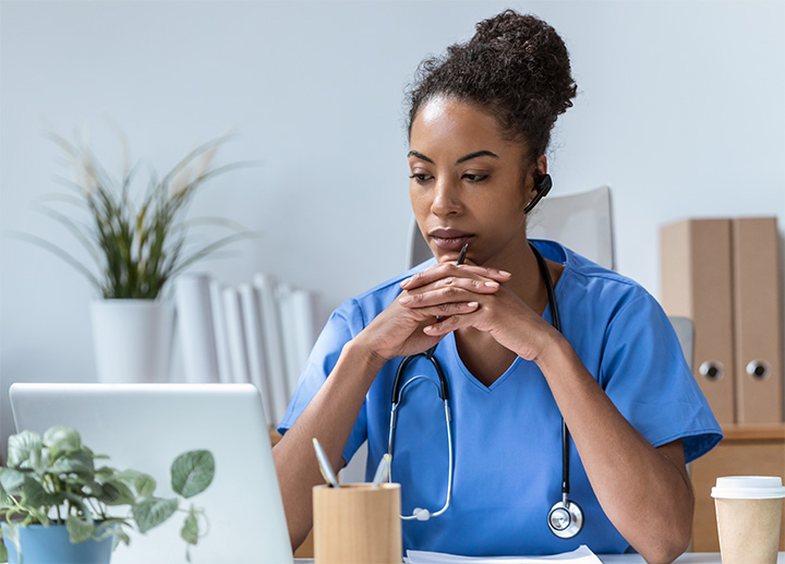 A healthcare professional working on a laptop.