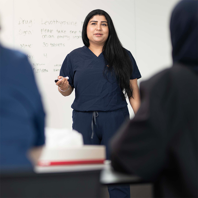 A nursing graduate student speaking in front of the class.