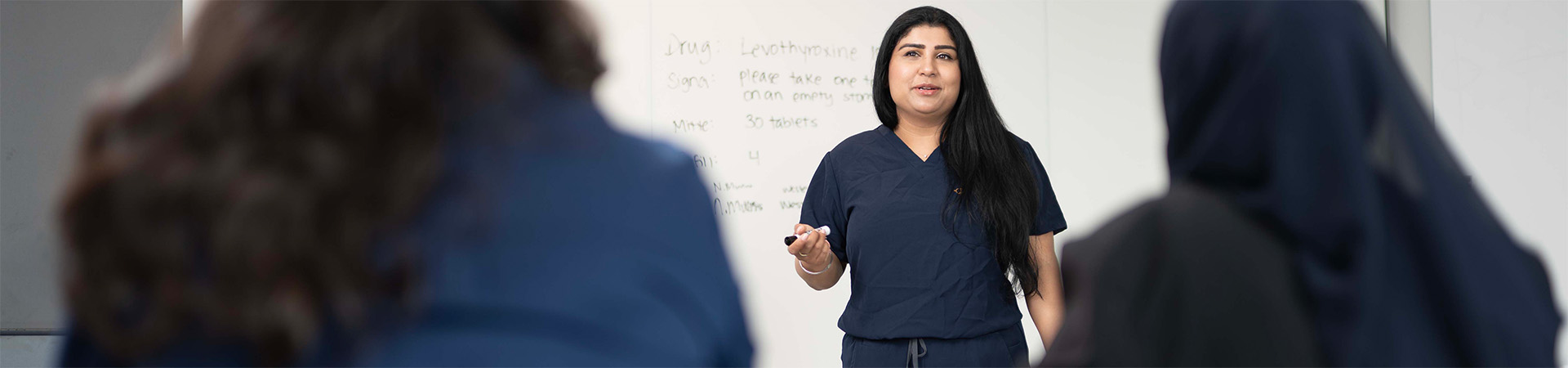 A nursing graduate student speaking in front of the class.