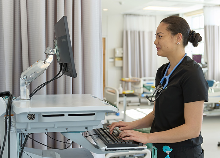 A nursing student entering information into a computer.
