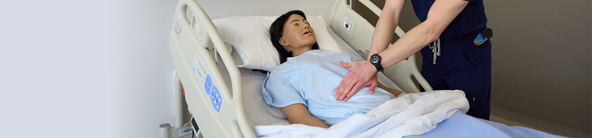 A nursing student practicing compressions on a manakin.