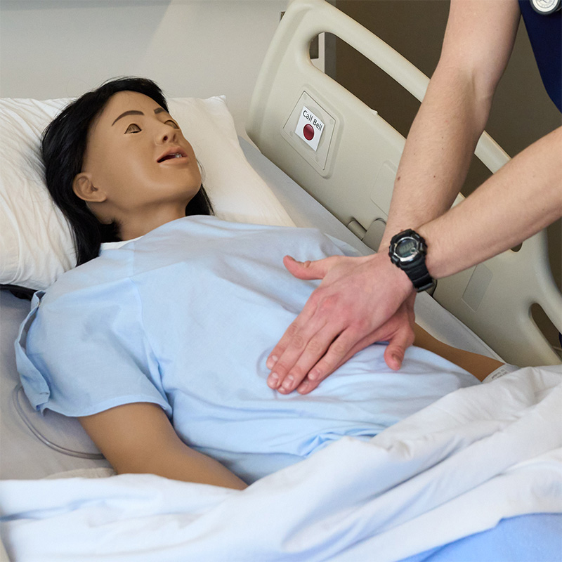 A nursing student practicing compressions on a manakin.