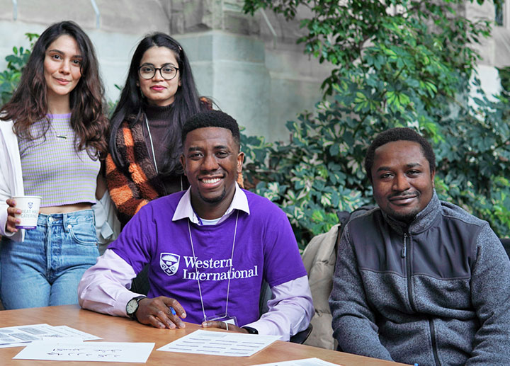 Group of international student sitting down and smiling at the camera