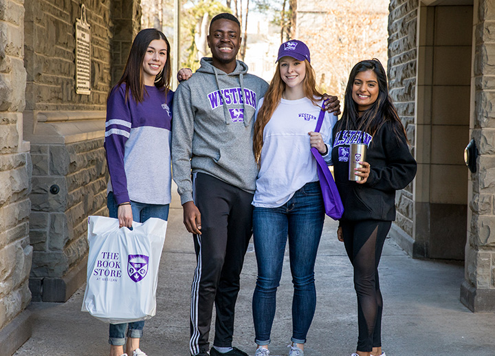 Group of Western students posing with Western University gear and fashion