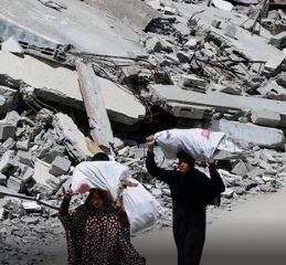 image of two women walking beside a bombed building