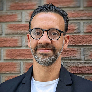 A portrait of Luis Patricio against a brick wall