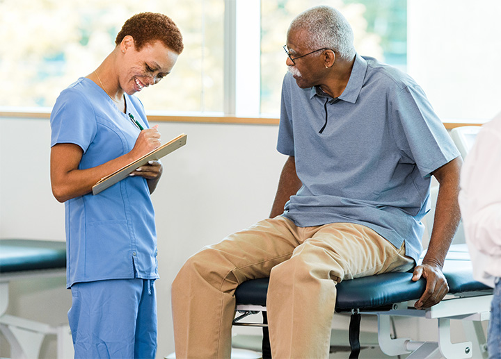 A patient sitting at a clinic speaking with a medical professional.