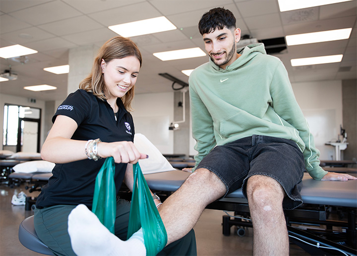 A Physical Therapy student inspecting someone's leg.