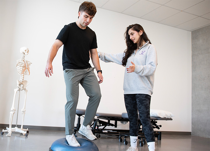 A man balancing on one foot while on top of a rubber cushion.