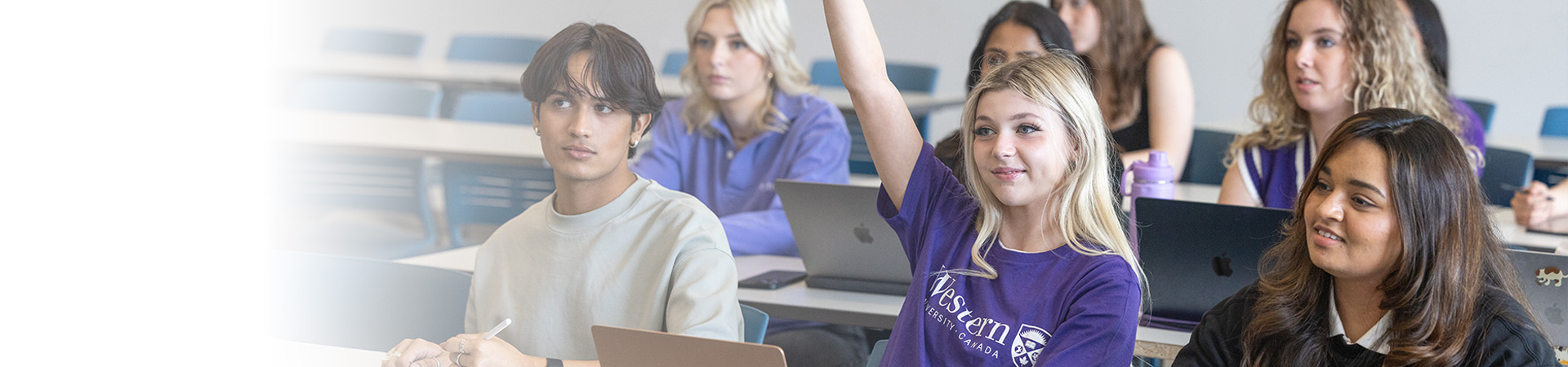 A student raising their hand in class.