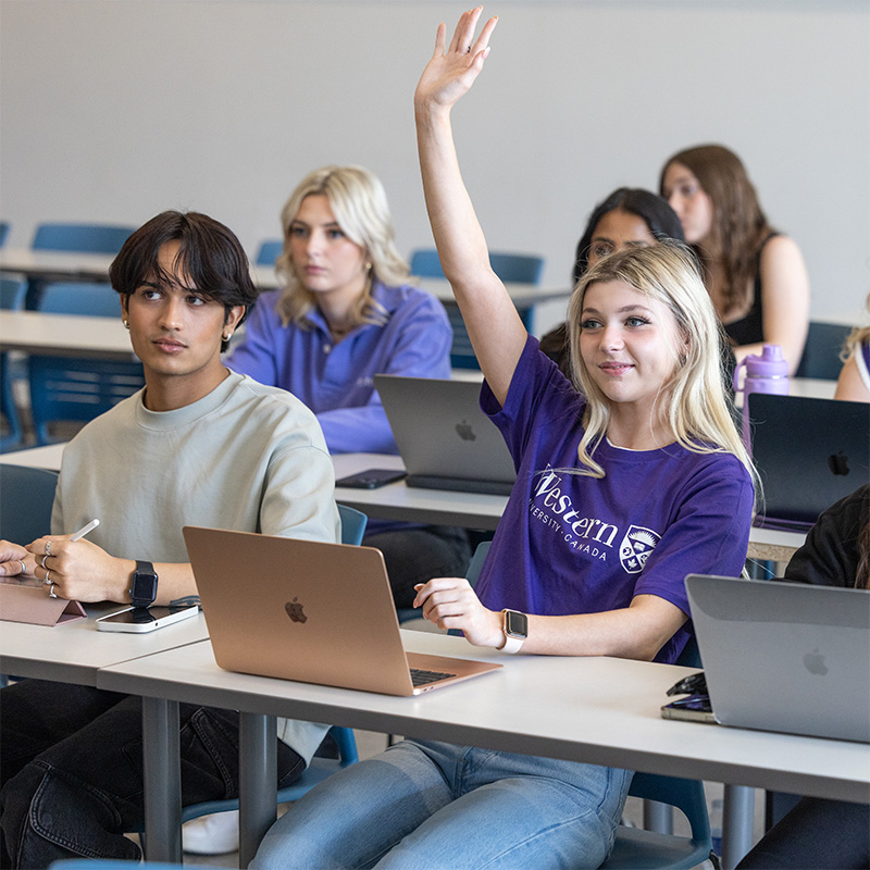 A student raising their hand in class.