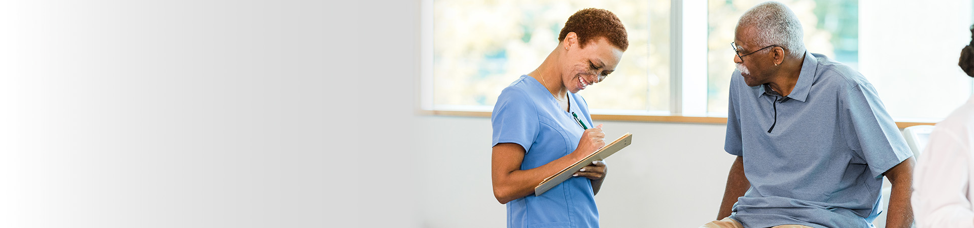 A patient sitting at a clinic speaking with a medical professional.