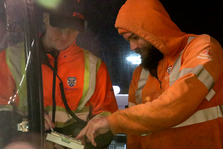 Two operators discussing their route on concrete beach