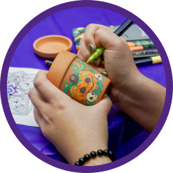 a hand painting a succulent pot.