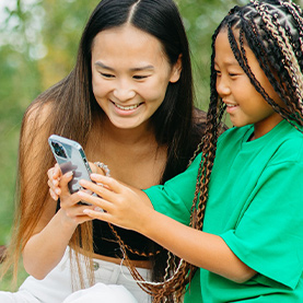 two your girls looking at phone screen together
