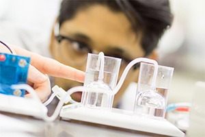 Student studying lab instruments at a work station