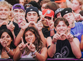 A crowd of Western students holding their hands in a W formation