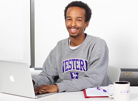 Student on a laptop wearing a Western sweatshirt