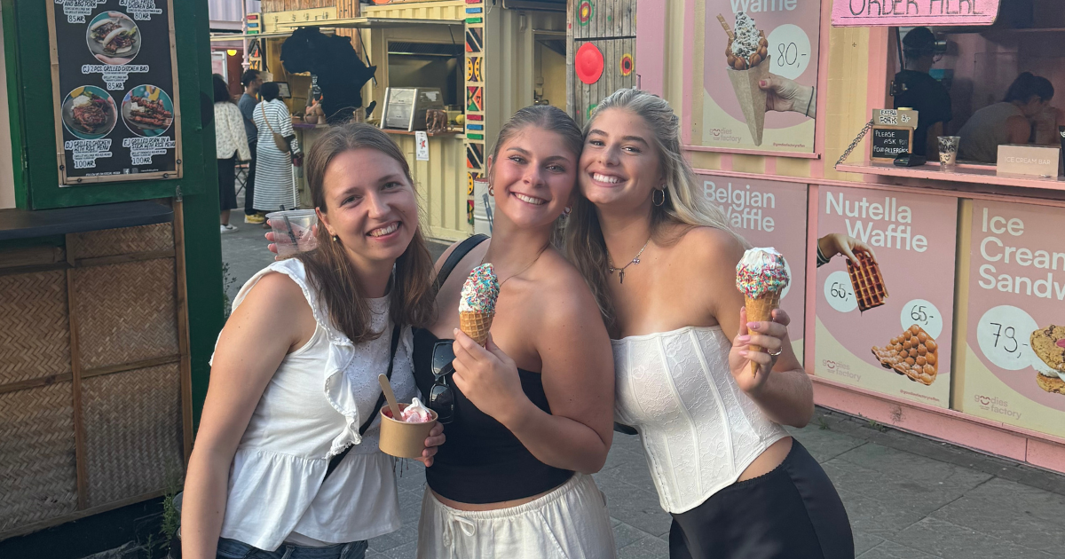 Tessa and two friends posing for a photo with an ice cream cone.