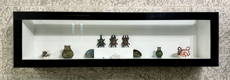 small ceramic bettles and rat in vitrine case