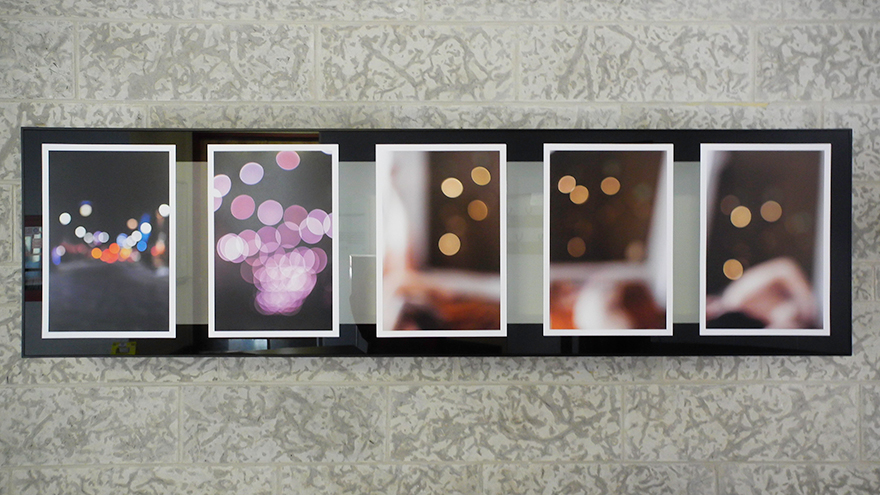 A view of four photographs of refracted, colourful light in warm tones