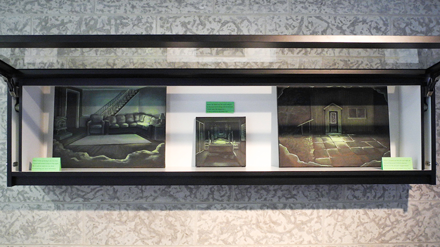 A view of a vitrine with three paintings showing an empty home at night with low, singular light sources