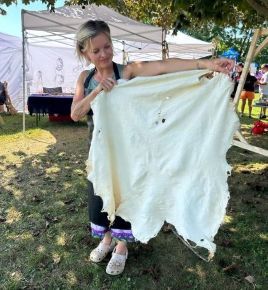 Indigenous Artist-in-Residence Jodi Maracle displaying a tanned hide